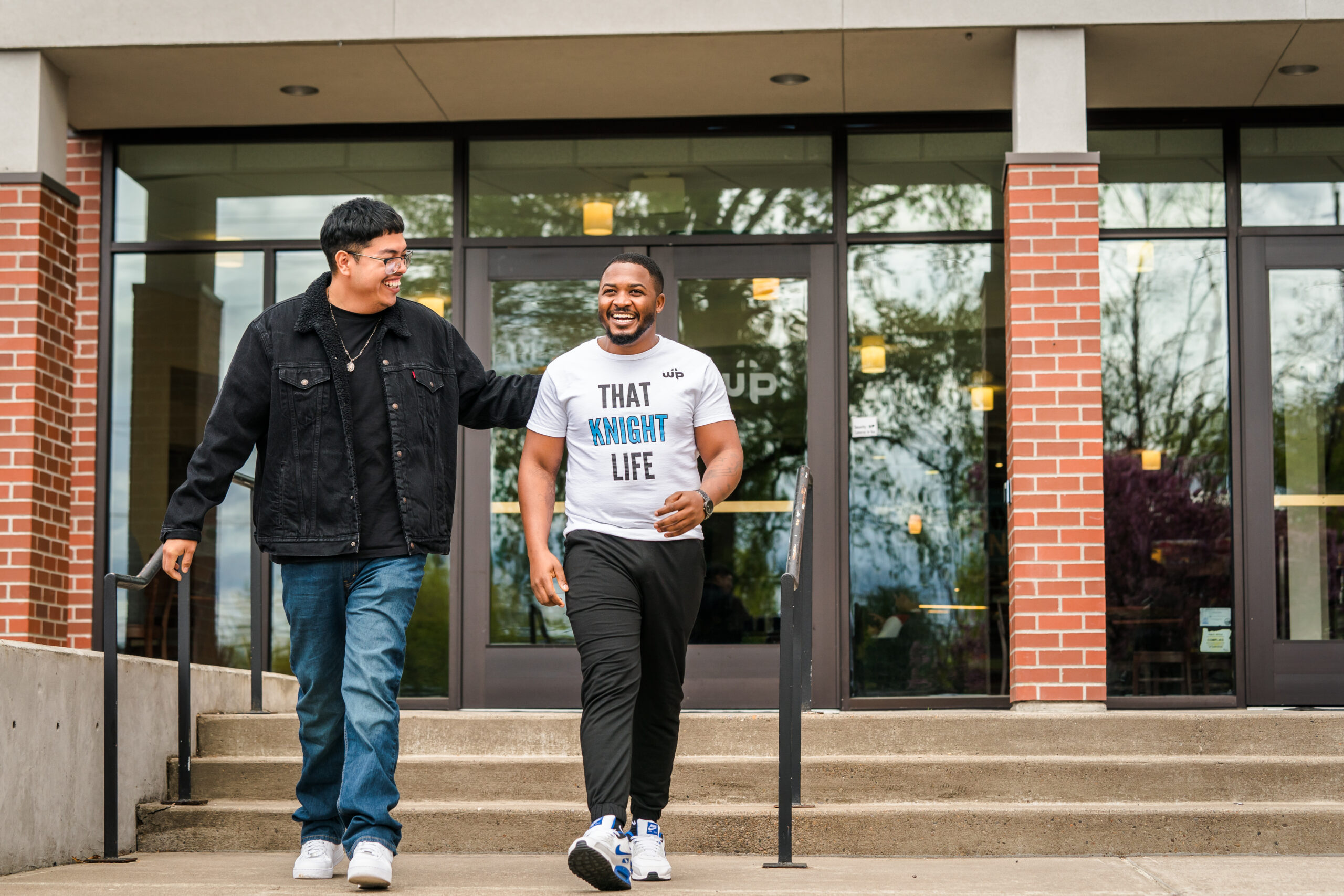 Two WPU students walking outside near a building on campus.