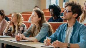 College students in a lecture hall listening to a professor.