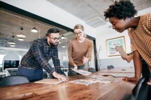 A project manager reviews some new product mockup designs with their team.