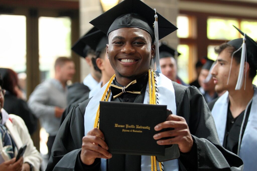 Student at graduation holding diploma.