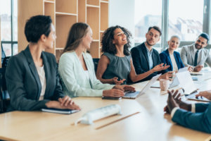 Businesspeople meet around a conference table.