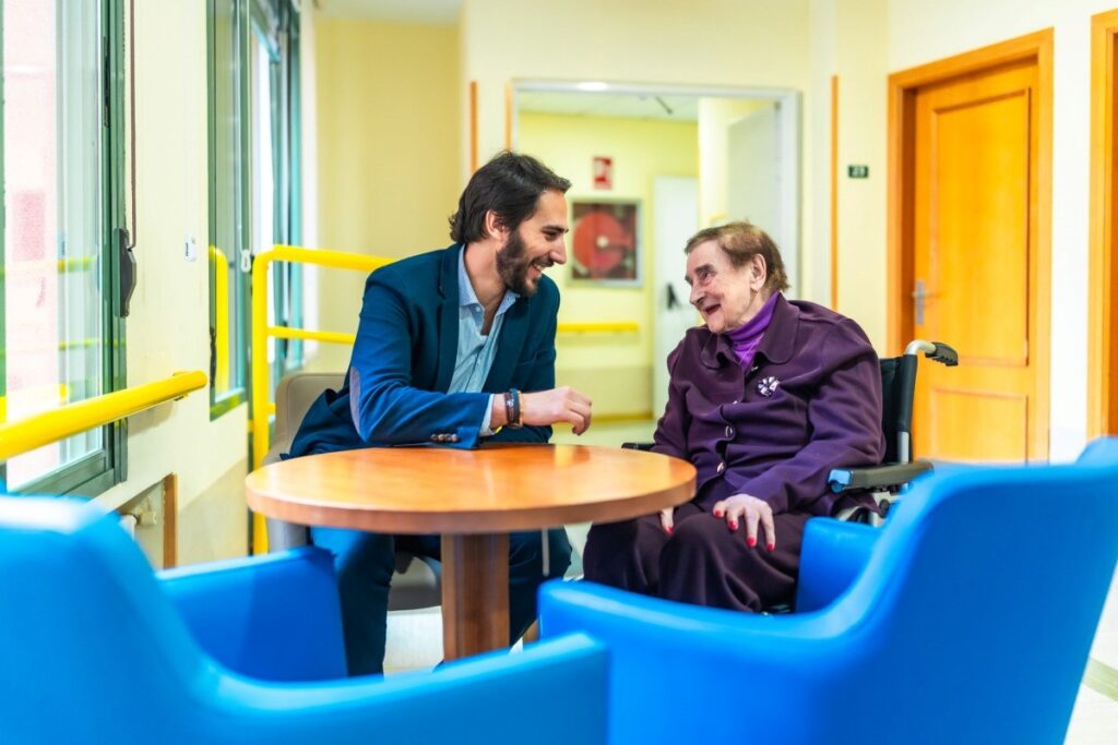 A nursing home administrator visits with a resident.